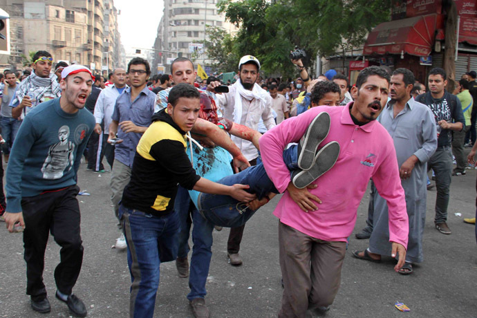 Egyptian Muslim brotherhood and supporters of ousted president Mohamed Morsi carry an injured comrade during clashes with riot police along Ramsis street in downtown Cairo on October 6, 2013. (AFP Photo)