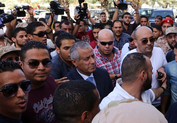 Libyan Prime Minister Ali Zeidan (C) arrives at the government headquarters in Tripoli on October 10, 2013 shortly after he was freed from the captivity of militiamen who had held him for several hours (AFP Photo / Mahmud Turkia) 