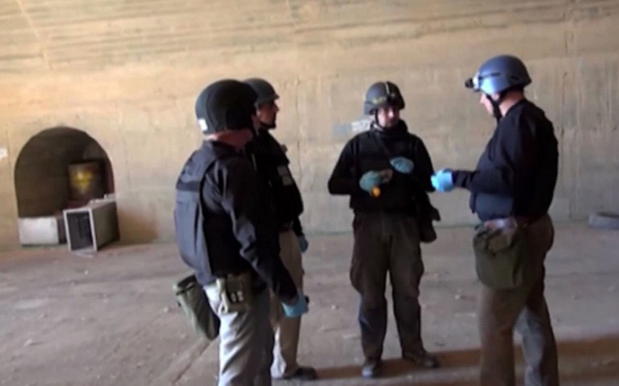 An image grab taken from Syrian television on October 10, 2013 shows inspectors from the Organisation for the Prohibition of Chemical Weapons (OPCW) at work at an undisclosed location in Syria. (AFP Photo)