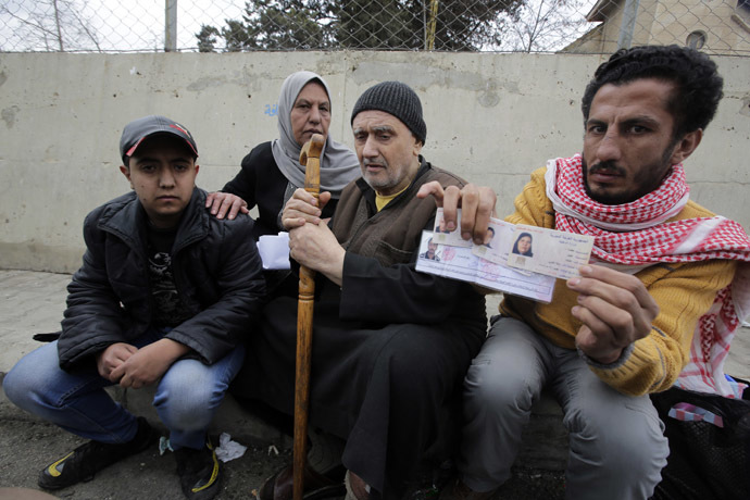 Palestinians who fled violence in the Syrian refugee camp of Yarmuk are seen at the Masnaa Lebanese border crossing with Syria as people stamp their documents before entering Lebanon (AFP Photo)