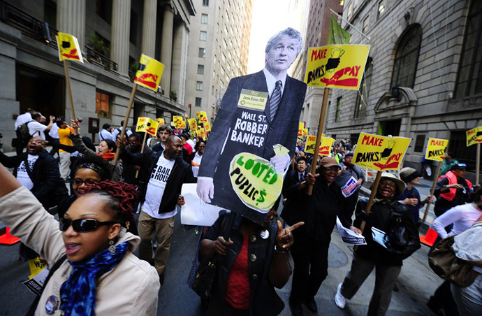 Labor-Community Coalition activists march down Wall Street holding a cutout of JP Morgan CEO Jamie Dimon, during a protest against budget cuts and bank practices, in New York, May 12, 2011. (AFP Photo / Emmanuel Dunand)