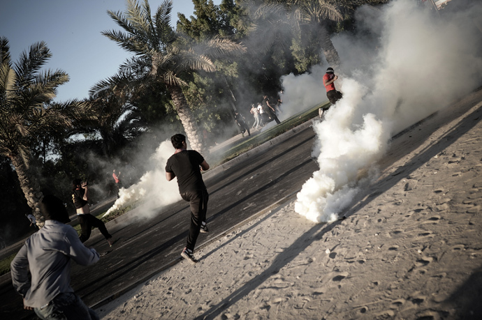 Bahraini protesters run away from tear gas and bird shot fired by riot police during clashes following the funeral of Ali Khalil Sabbagh in the village of Bani Jamrah, west of Manama, on October 23, 2013 (AFP Photo / Mohammed Al-Shaikh)