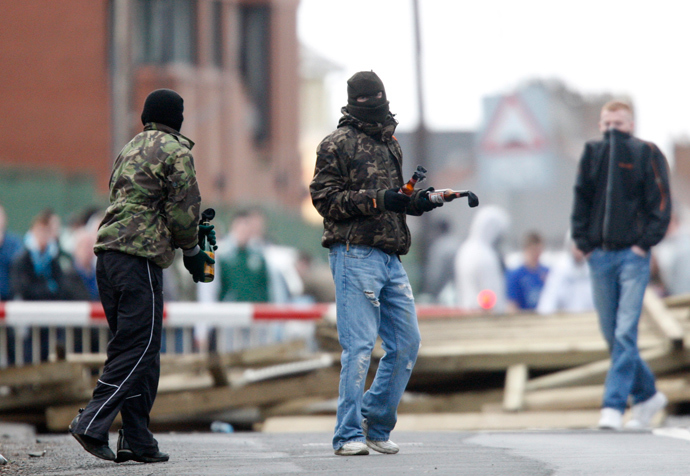 Masked youths prepare to throw molotov cocktails as they block the railway line near the house of former Irish Republican Army (IRA) man Colin Duffy in Lurgan, southwest of Belfast and Bellaghy, Northern Ireland (AFP Photo / Peter Muhly)