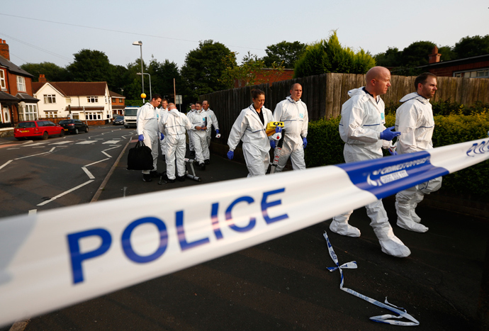 Police forensic officers walk behind a police cordon after an expolosion in Tipton, central England, July 12, 2013 (Reuters / Darren Staples)