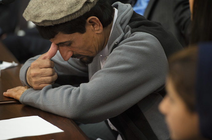 Rafiq ur Rehman takes a moment after speaking about the US drone strike in Pakistan that killed his mother and injured his daughter Nabila Rehman (R), 9,during a press conference on Capitol Hill in Washington, DC, October 29, 2013. (AFP Photo/Jim Watson)
