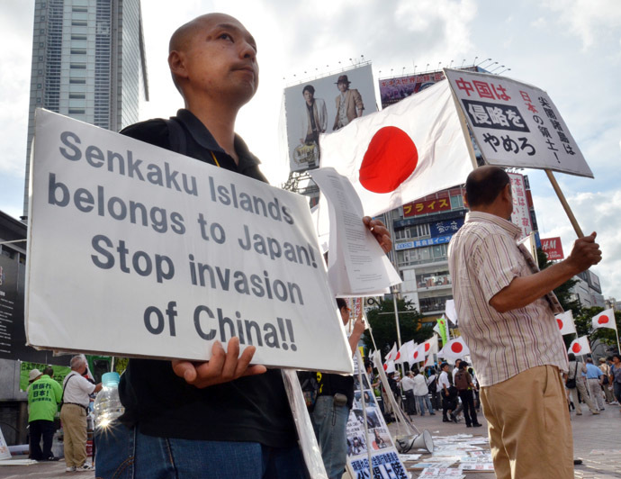 Japanese nationalists carry national flags and placards during a rally over the Senkaku islands issue, known as the Diaoyu islands in China, in Tokyo on September 18, 2012. (AFP Photo/Yoshikazu Tsuno)