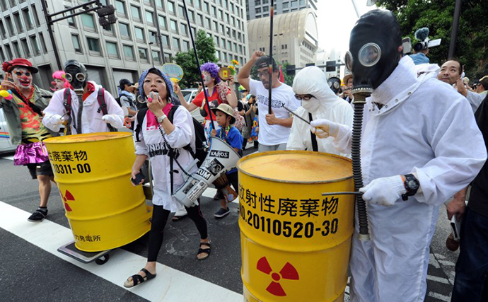 Protesters wearing gas masks and white costumes similar to those of decontamination workers at the crippled Fukushima plant beat drums painted with radioactive waste symbols during an anti nuclear power demonstration march in Tokyo (AFP Photo / Kazihiro Nogi)