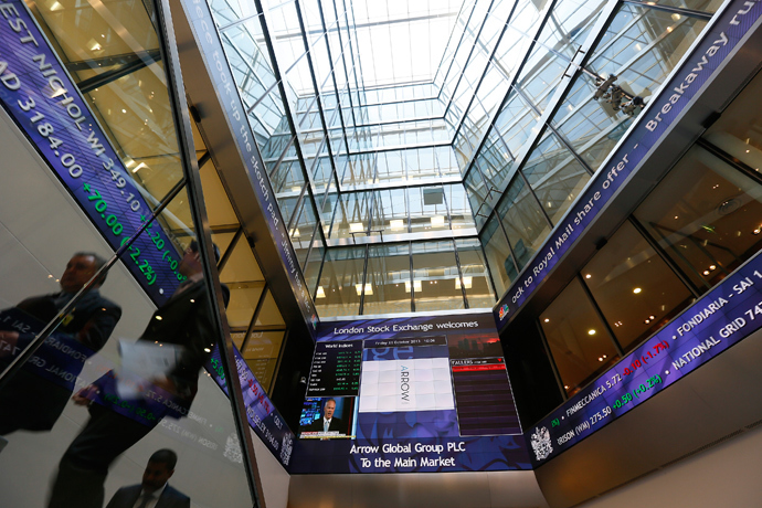 People pass electronic information boards at the London Stock Exchange in the City of London (Reuters / Stefan Wermuth)