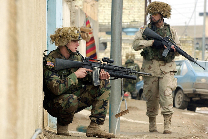 Two US soldiers from the 1st battalion, 22nd Regiment of the 4th Infantry Division secure the parameters during a foot-patrol along a street of former Iraqi dictator Saddam Hussein's hometown Tikrit, 180 Kilometers (110 miles) north of Iraqi capital Baghdad, 27 December 2003 (AFP Photo / Jewel Samad) 