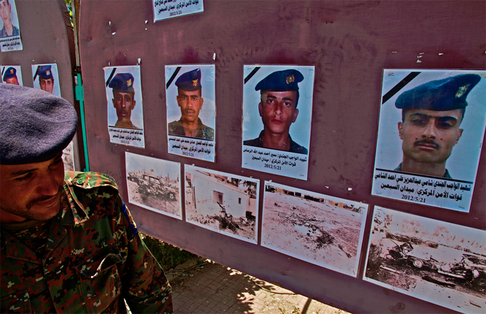 A Yemeni solider examines photographs of victims of a suicide bombing carried out by AQAP at a military parade rehearsal in Yemenâs capital in May 2012. (Photo by Nile Bowie)