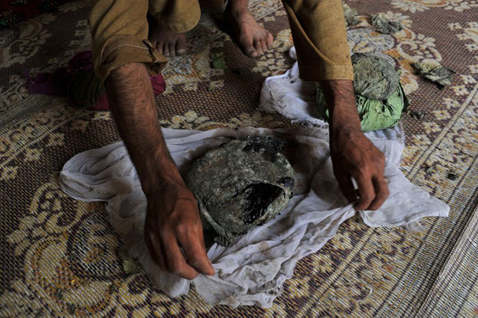 An Afghan man wraps a package of opium after harvesting from his poppy field in Pachir district of Nangarhar province (AFP Photo / Noorullah Shirzada)