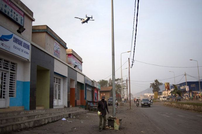 A man stands in a street as an aircraft comes in to land in Goma in the east of the Democratic Republic of the Congo on August 1, 2013 (AFP Photo / Phil Moore)