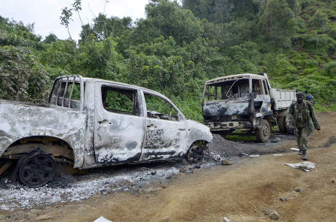 A Democratic Republic of Congo Army soldier walks on November 5, 2013 past trucks burnt by M23 rebels near Chanzu, 80 kilometres north of regional capital Goma, in the eastern North Kivu region that was one of the rebels' last stands. (AFP Photo / Junior D. Kannah)