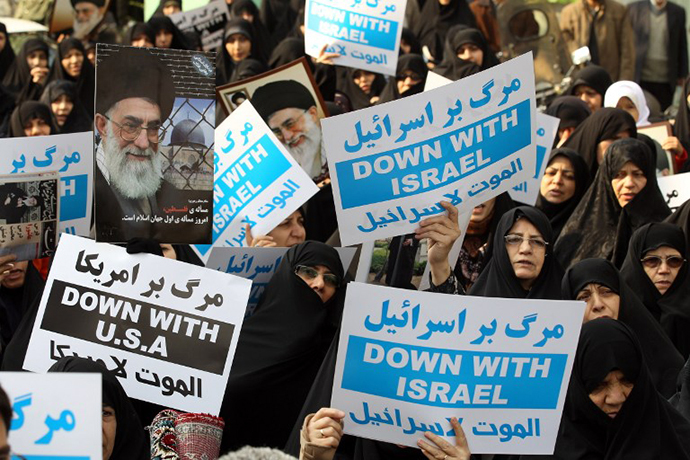 Iranians hold portraits of the Islamic republic's supreme leader, Ayatollah Ali Khamenei, and anti-Israel placards during a protest on November 16, 2012. (AFP Photo)