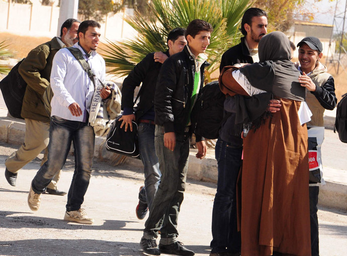 Mother Agnes-Marie de la Croix (R) and the Red Cresent (unseen) with the help of the Social Affairs Ministry, receive Syrian civilians as they evacuate the war-battered suburb of Damascus, Moadamiyet al-Sham, as fighting between pro-government troops and rebel fighters continues in districts of the capital, on October 29, 2013. (AFP Photo)