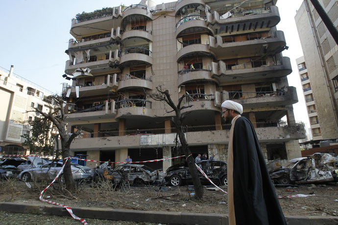 A Shiite cleric walks past a damaged building on November 20, 2013 at the scene of the previous day's double suicide bombing outside the Iranian embassy in Beirut in which at least 23 people were killed.(AFP Photo / Anwar Amro)