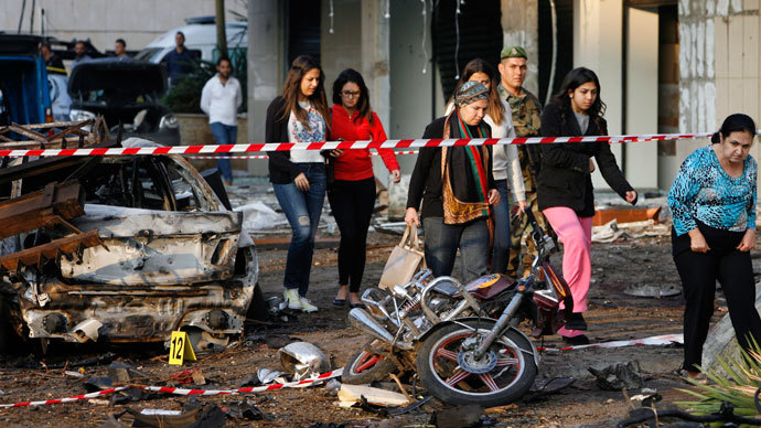 Lebanese onlookers walk on the site of a double suicide bombing outside Iran's embassy in Bir Hassan neighbourhood in southern Beirut on November 19, 2013.(AFP Photo / STR)