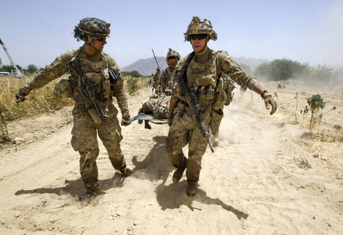 U.S. Army soldiers carry Sgt. Matt Krumwiede, who was wounded by an improvised explosive device (IED), towards a Blackhawk Medevac helicopter in southern Afghanistan June 12, 2012. (Reuters/Shamil Zhumatov)