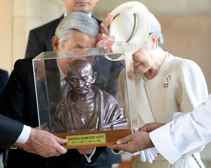 Japanese Emperor Akihito (C) and Empress Michiko (R) are assisted an unseen Indian External Affairs Minister Salman Khurshid as they receive a bust of Mahatma Gandhi from officials during a visit to Rajghat, the memorial to Mahatma Gandhi in New Delhi on December 2, 2013. (AFP Photo / Prakash Singh)