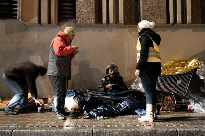 Volunteers of the French charity Les Restos du Coeur (Restaurants of the Heart) distribute on November 25, 2013 hot meals to homeless people in the streets of the eastern French city of Strasbourg. (AFP Photo / Frederic Florin)