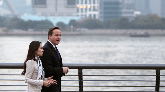 British Prime Minister David Cameron walks along the Bund with Lisa Pan, vice president of Chinese mobile gaming company Rekoo, in Shanghai December 3, 2013. Picture taken December 3.(Reuters / China Daily)
