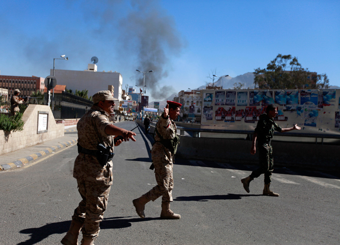 Soldiers gesture along a road leading to the Defence Ministry's compound as smoke rises after an attack, in Sanaa December 5, 2013. (Reuters / Mohamed al-Sayaghi) 