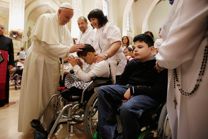 Pope Francis blesses a disabled person during his visit at the Serafico Institue in Assisi October 4, 2013. (Reuters / Gregorio Borgia / Pool)