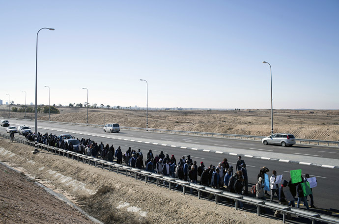 African illegal immigrants take part in a protest march on the highway near Lahav junction in southern Israel on their way to Jerusalem on December 16, 2013 after they fled a detention centre in the south where they were being held. (AFP Photo/Oren Ziv)