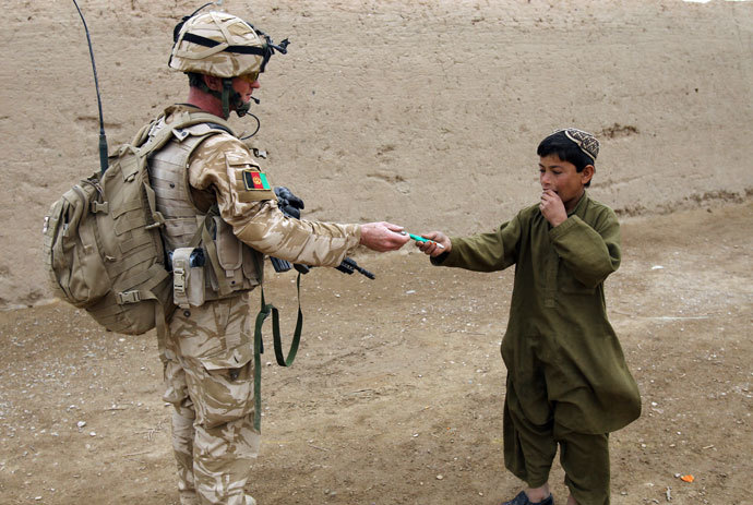 A British soldier of the 1st batallion of the Royal Welsh gives a pen to an Afghan boy during a patrol in the streets of Showal in Nad-e-Ali district, Southern Afghanistan.( AFP Photo / Thomas Coex)