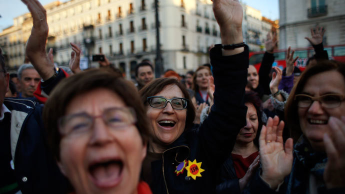 Demonstrators sing and raise their hands during a gathering to mark the second anniversary of the 15M movement at Madrid's landmark Puerta del Sol Square May 15, 2013.(Reuters / Susana Vera)