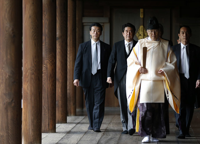 Japan's Prime Minister Shinzo Abe (2nd L) is led by a Shinto priest as he visits Yasukuni shrine in Tokyo December 26, 2013. (Reuters/Toru Hanai)