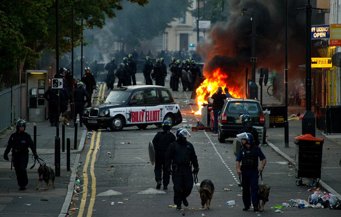 In a file picture taken on August 8, 2011 riot police tackle a mob after a number of cars are set alight in Hackney, north London on the third day of disorder following a protest against the police shooting of Mark Duggan. (AFP Photo / Leon Neal)