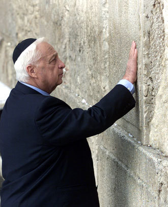 Prime Minister elect Ariel "Arik" Sharon touches the stones of the Western Wall, also known as the Wailing Wall, as he prays while visiting Judiasm's holiest site in Jerusalem's Old City February 7, 2001.(Reuters / Jwh / aa)
