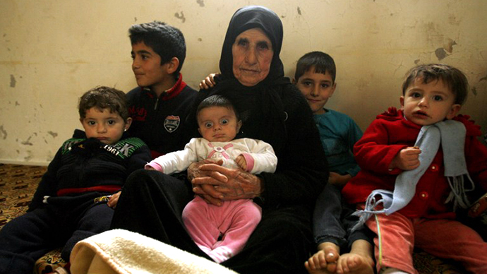 Hallum Al-Amin, a Syrian refugee, sits with members of her family in a house in the village of Qalawayeh, near the southern Lebanese town of Tyre, on January 12, 2014. (AFP Photo / Mahmoud Zayyat)