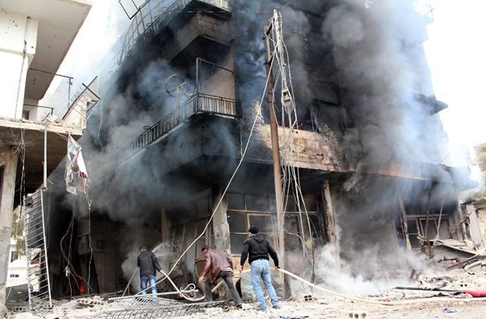 A picture taken on January 12, 2014, shows men trying to put out a fire in a buildings in the city of Daraya, southwest of the capital Damascus. (AFP Photo / Hussam Ayash)