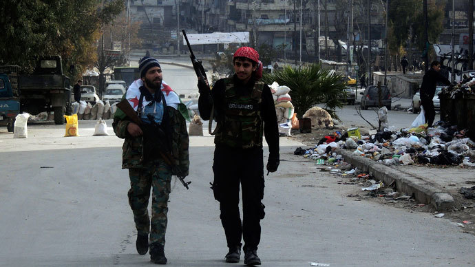 Syrian rebel fighters hold their weapons as they walk along a street in Aleppo's Salaheddine neighbourhood January 10, 2014. REUTERS/Hosam Katan 