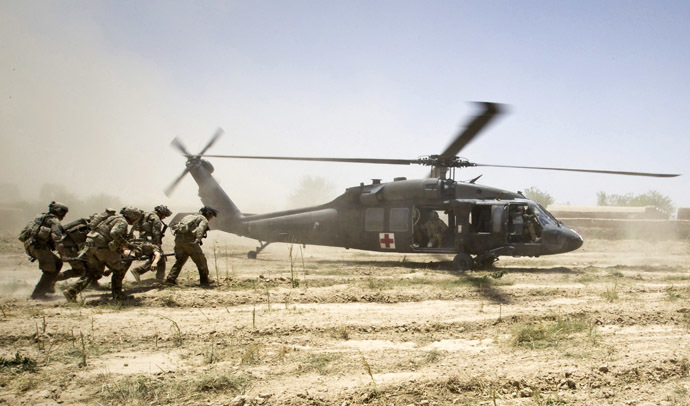 U.S. Army soldiers carry Sgt. Matt Krumwiede, who was wounded by an improvised explosive device (IED), towards a Blackhawk Medevac helicopter in southern Afghanistan in this June 12, 2012 file photo. (Reuters/Shamil Zhumatov)