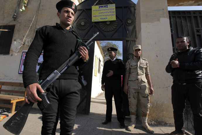 Egyptian police and a soldier stand guard outside a polling station during a referendum on the new constitution in Cairo, January 15, 2014. (Reuters)