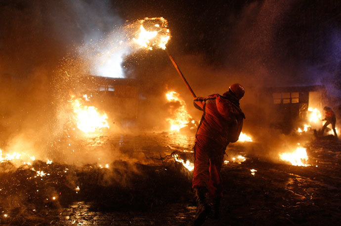 A pro-European protester throws a burning tyre during clashes with riot police in Kiev January 22, 2014.(Reuters / Vasily Fedosenko )