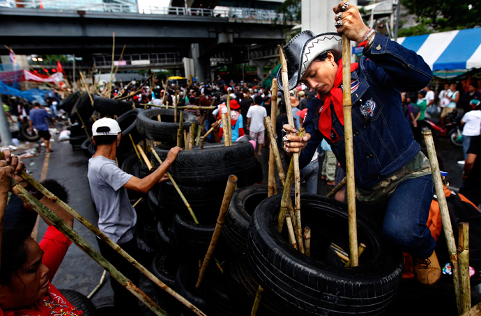 An anti-government 'red shirt' supporter helps dismantle a barricade set in front of Bangkok's Chulalongkorn hospital on May 1, 2010. (Reuters / Jerry Lampen)