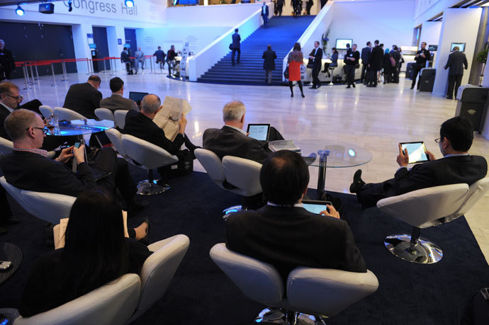 Participants read in the congress center at the World Economic Forum in Davos on January 23, 2014.(AFP Photo / Eric Piermont)