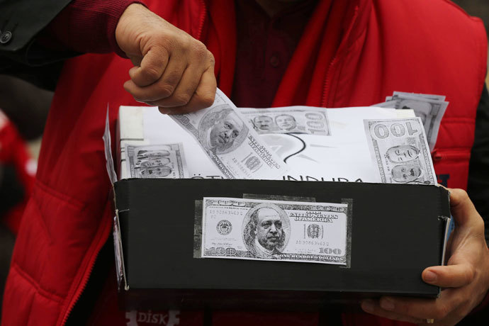 A demonstrator carries a shoe box, a symbol of the corruption scandal after police found $4.5 million secreted in shoe boxes in the home of the chief executive of Turkish state-owned Halkbank, during an anti-corruption protest in Ankara on January 11, 2014.(AFP Photo / Adem Altan )
