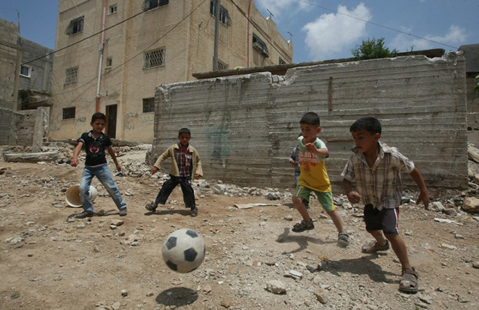 Palestinian boys play football outside their homes at the refugee camp of al-Fawar in the West Bank town of Hebron on May 14, 2012. (AFP Photo / Hazem Bader)