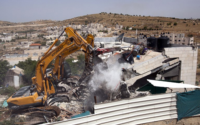 Israeli municiplaity bulldozers destroy a Palestinian house in the Arab east Jerusalem neighborhood of Beit Hanina, on May 29, 2013. (AFP photo / Ahmad Gharabli)