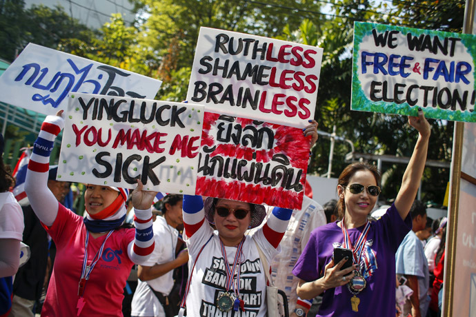 Anti-government protesters hold placards during a march through central Bangkok January 30, 2014. (Reuters/Athit Perawongmetha)