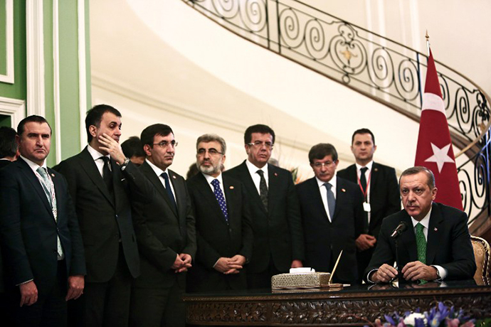 The Turkish delegation stand as Turkish Prime Minister Recep Tayyip Erdogan (R) speaks to the media during a meeting with Iranian officials at Tehran's Saadabad palace on January 29, 2014. (AFP Photo / Behrouz Mehri)