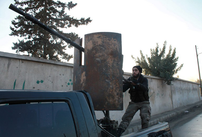 An opposition fighter sits on the back of an armed pick-up truck in the northern Syrian city of Aleppo on January 7, 2014 during ongoing clashes with fighters of the jihadist Islamic State of Iraq and the Levant (ISIL). (AFP Photo / Mohammed Wesam)