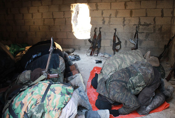 Members of the jihadist group Al-Nusra Front pray as they hold a position along the front line nearby on February 8, 2014 in the Syrian village of Aziza, on the southern outskirts of Aleppo. (AFP Photo / Baraa Al-Halabi)