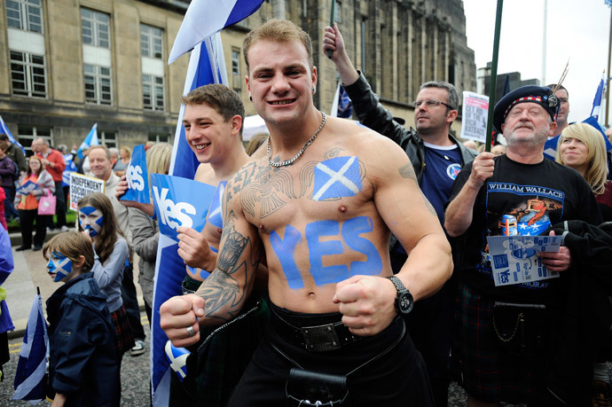 A pro-independence supporter with a Saltire flag and a "Yes" written on his body joins a march and rally in Edinburgh on September 21, 2013 in support of a yes vote in the Scottish Referendum to be held in September 2014.(AFP Photo / Andy Buchanan)