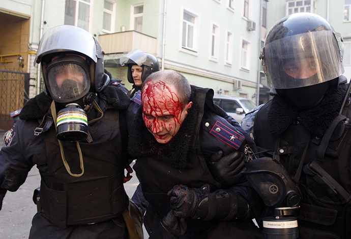 Policeman evacuate a wounded colleague during clashes with anti-government rioters in Kiev on February 18, 2014. (AFP Photo / Anatoliy Stepanov)